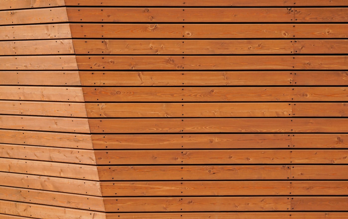 Close up of warm cedar cladding boards with neat stainless fixings